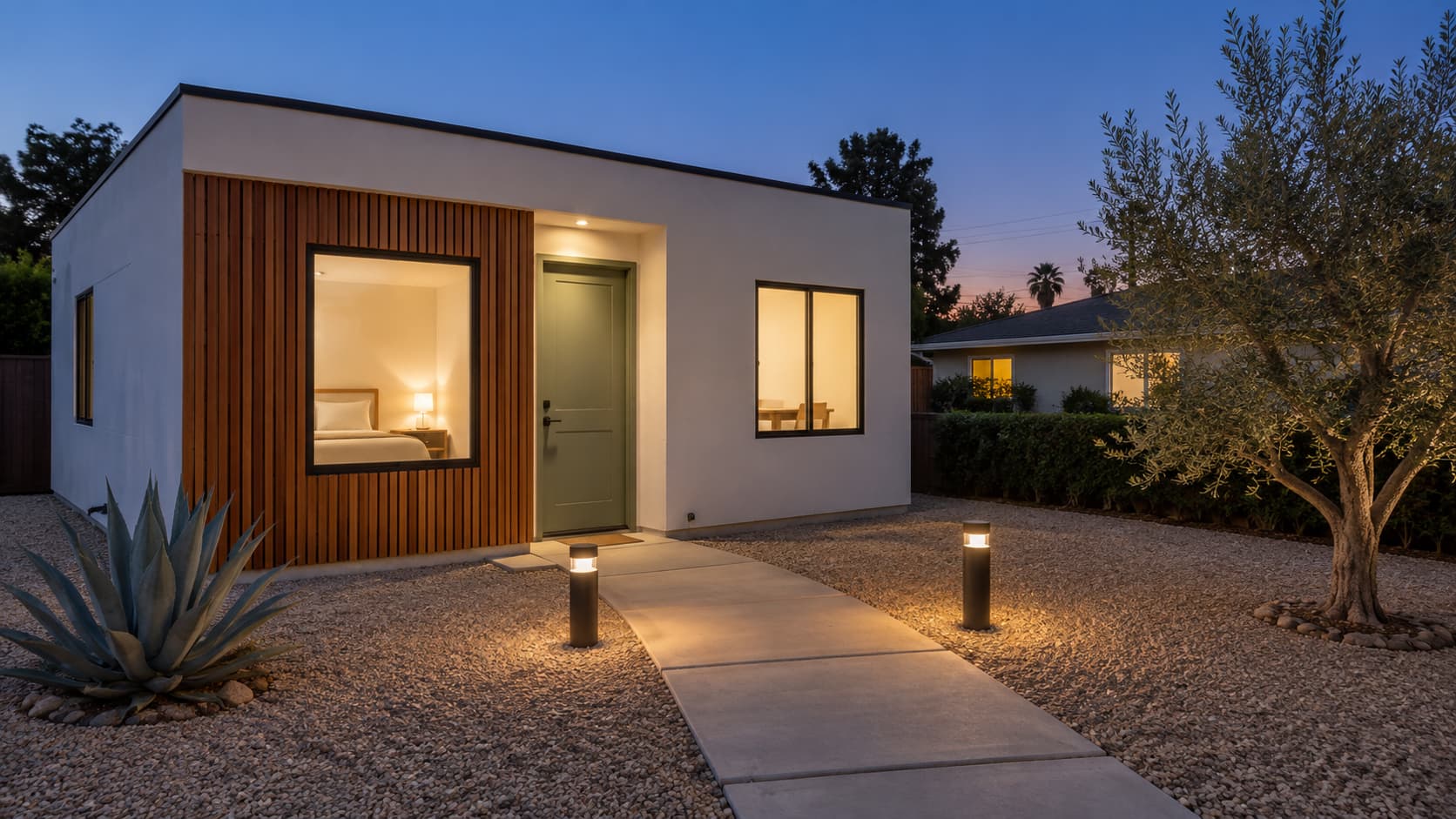 A modern ADU at blue hour with warm lit windows ready for a tenant